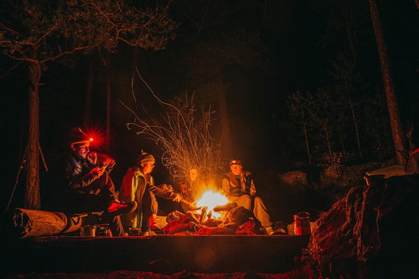 What are the pros and cons of wild camping versus designated camping sites in the UK?